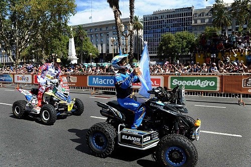 El argentino Sebastian Halperín, con la bandera nacional, larga el Dakar desde Plaza de Mayo.