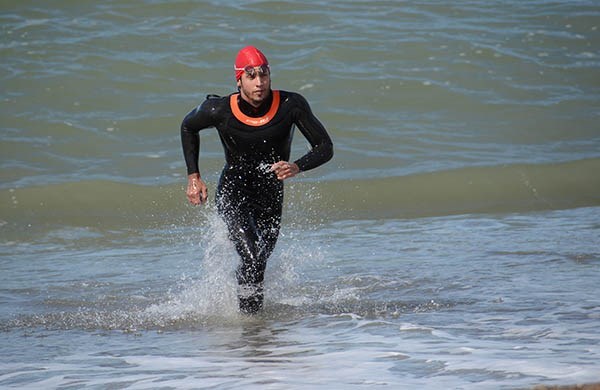El nadador capitalino Maximiliano Aragón, saliendo del agua en la costa de Playa Unión, bajo las toninas.