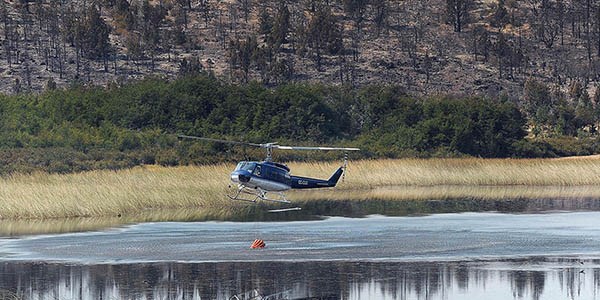 Aviones hidrantes y helicópteros buscan por la vía aérea enfriar las zonas donde están los focos.