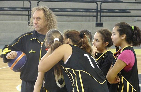 El director técnico Gustavo López junto a las chicas del equipo femenino de básquet de Deportivo Madryn.