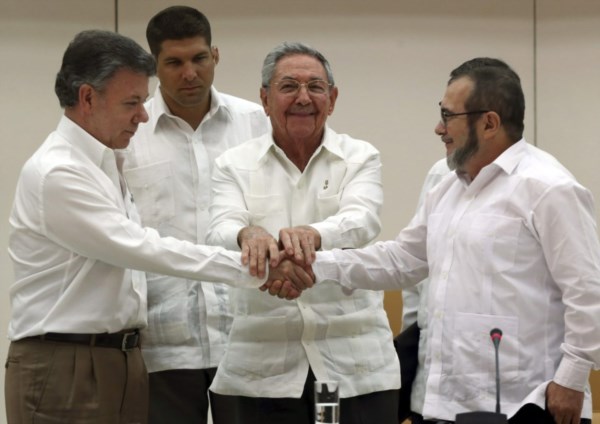 El presidente Santos, su par de Cuba Raúl Castro y el máximo líder de las FARC, Rodrigo Londoño, alias "Timochenko", se dan la mano, durante un acto en La Habana.
