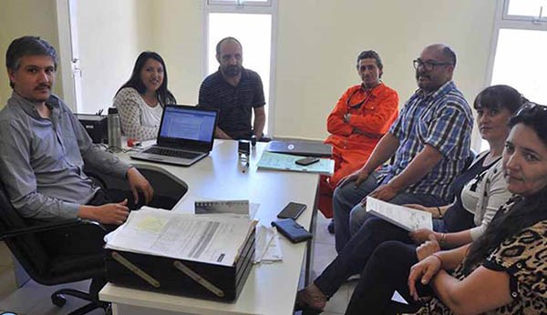 Trato hecho. Las partes posan luego de firmar el  acuerdo. 
