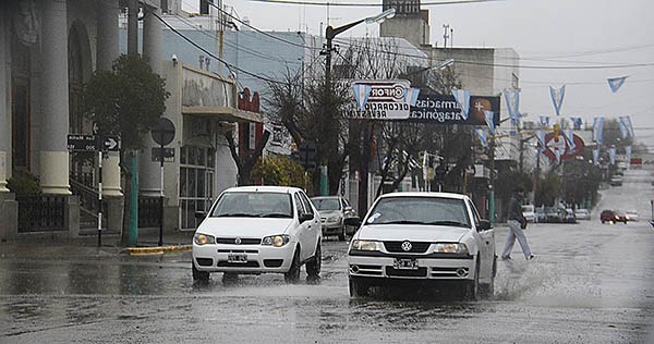 Dos rodados avanzan en medio de la lluvia caída ayer. No fue necesario realizar evacuaciones, según se dijo.