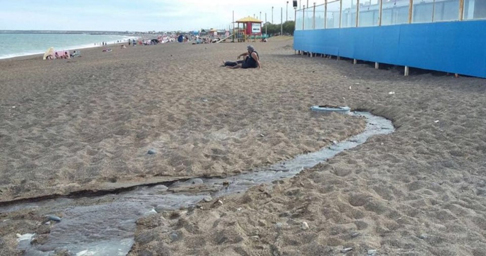 Como para broncearse. Detrás del local el líquido se desparrama en una playa muy concurrida por familias.