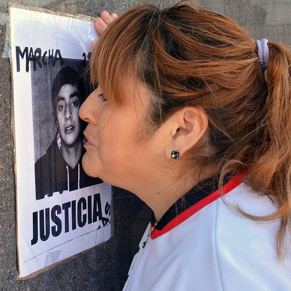 Dolor. Zulma Díaz, madre de Lucas, besa una postal de su hijo.