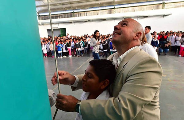 Alta en el cielo. El intendente Sastre iza la bandera junto con uno de los alumnos que empezó las clases. 