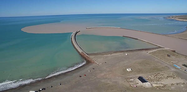 Así llega. Una postal de la desembocadura del río Chubut en Puerto Rawson, donde la turbiedad que viene del dique le da un tono diferente.