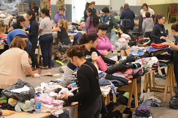 A full. Los vecinos solidarios se dedican a clasificar la ropa que se donó en el Predio Ferial de Comodoro. 