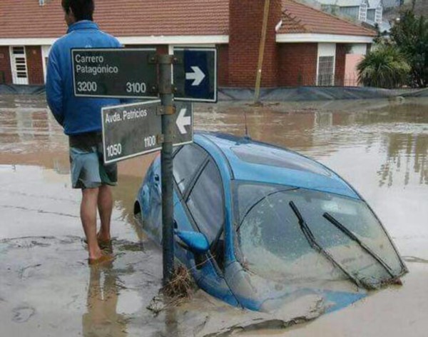 Hundido. Uno de los jóvenes damnificados por el temporal y un vehículo que ya no podrá recuperarse. 