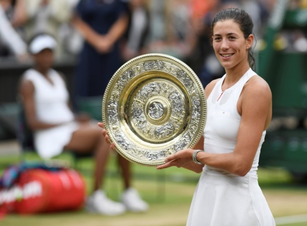 Garbiñe Muguruza posando con su trofeo que la acredita como la campeona de Wimbledon.