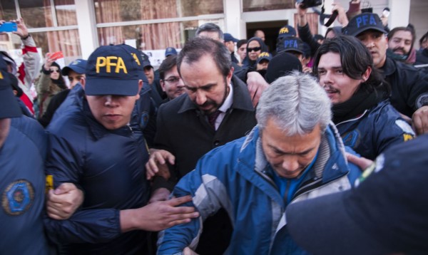 Ojo de la tormenta. El juez Otranto debió recurrir a un fuerte cordón policial ante el enojo de los manifestantes y entre insultos y empujones.