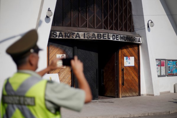 Un carabinero toma fotografías del frente de una de las iglesias católicas atacadas este viernes.