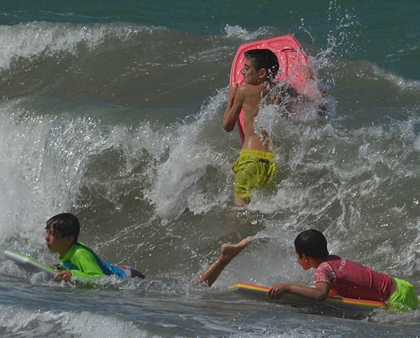Niños “surfistas” experimentando el desafío de cabalgar olas.