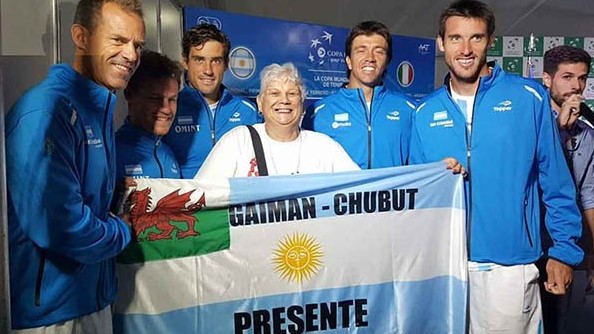 Nélida Dos Santos sostiene orgullosa la bandera nacional junto al equipo argentino de Copa Davis.