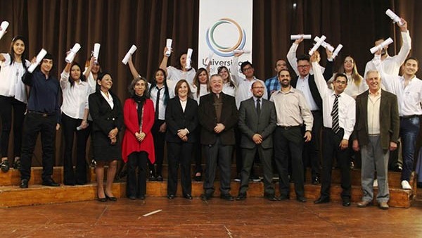 Los nuevos egresados de la Universidad del Chubut celebran la obtención de su título profesional.
