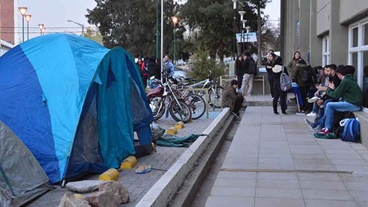 Las carpas que empezaron a montar sobre el playó de la Universidad Nacional de la Patagonia en Trelew.