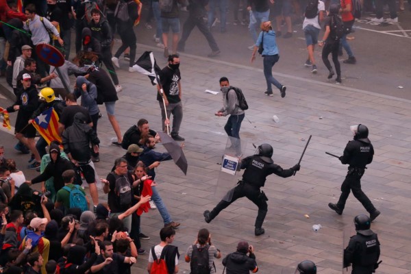 Manifestantes se enfrentan con policías españoles frente al aeropuerto de El Prat en Barcelona.