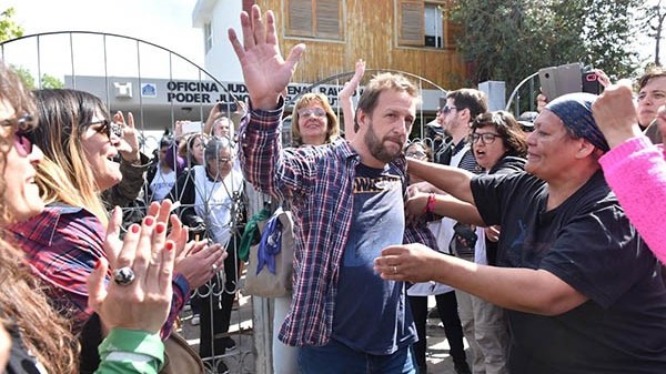 Aplausos. Muy serio, una postal de Goodman tras ser liberado y yéndose de la Oficina Judicial de Rawson. 
