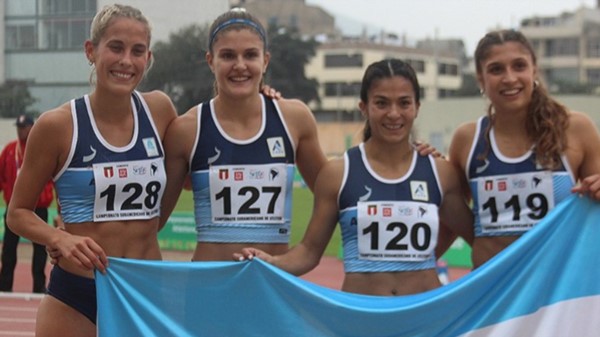 María Ayelén Diogo con sus compañeras de equipo y la bandera nacional. Fueron terceras en la posta 4x400.