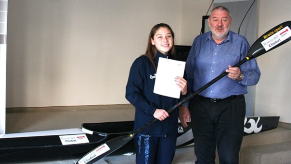Candela Velázquez recibe un kayak y un remo de manos de Julio Ramírez.