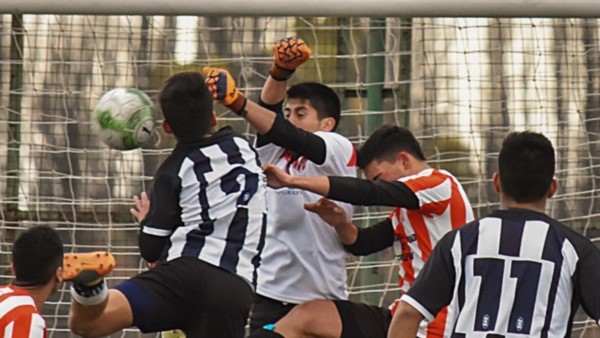 El arquero Herrera intenta despejar un balón ante la mirada de Eros Jara (Racing) y de  Rodríguez (Ever Ready).