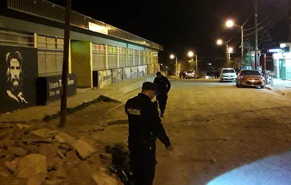 Efectivos policiales inspeccionando la arteria donde se produjo una balacera en una madrugada violenta.