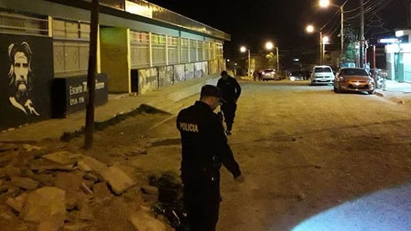 Efectivos policiales inspeccionando la arteria donde se produjo una balacera en una madrugada violenta.