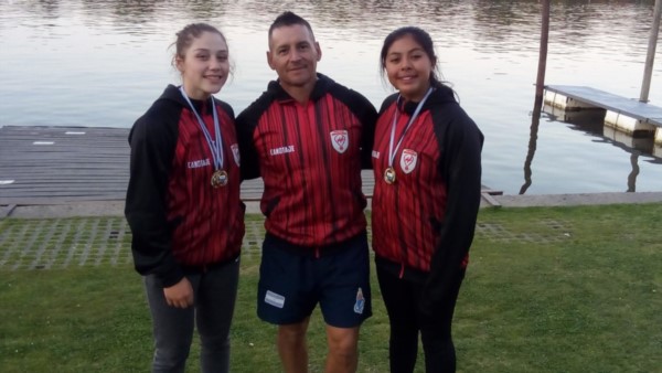 Manolo Velázquez, posa junto a dos palistas del club Huracán. Los deportistas se preparan para realizar la Medio Maratón el próximo 25 y 26 de enero.