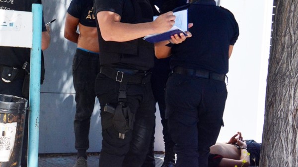 Efectivos policiales detienen a los sujetos que tiraron piedras.