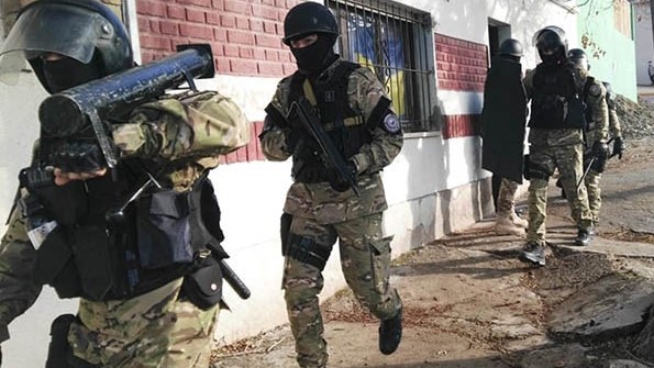 El tumbador de puertas es seguido a trote por otros miembros del GIR, a fines de localizar armas de fuego.