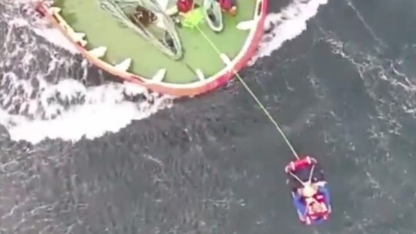Momento en que se efectúa el rescate del marinero con la canasta sanitaria del helicóptero de la fuerza.