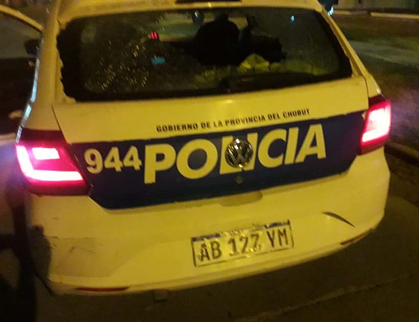 Uno de los cristales del móvil policial fue dañado en la trifulca.
