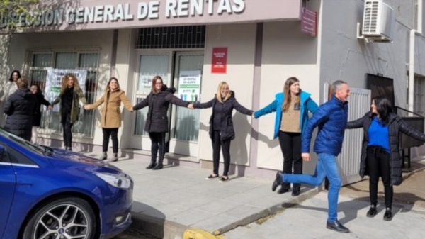 A correr. Uno de los empleados que llegó tarde para el abrazo simbólico se apura para colocarse junto con sus compañeros en la sede central.