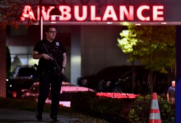 Un oficial de policía armado protege la entrada de ambulancias del Centro Médico Central Maine en Lewiston, Maine.