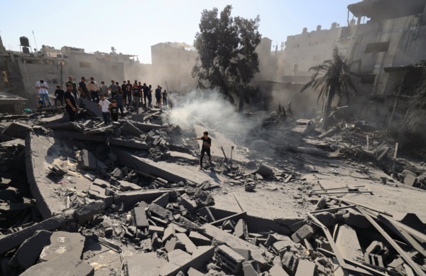 Palestinos buscan sobrevivientes y los cuerpos de las víctimas entre los escombros de los edificios destruidos durante el bombardeo israelí.