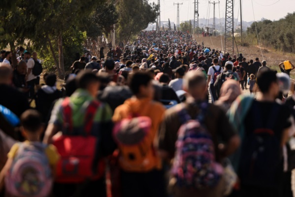 Familias palestinas que huyen de la ciudad de Gaza y otras partes del norte de Gaza hacia las zonas del sur, caminan por una carretera.