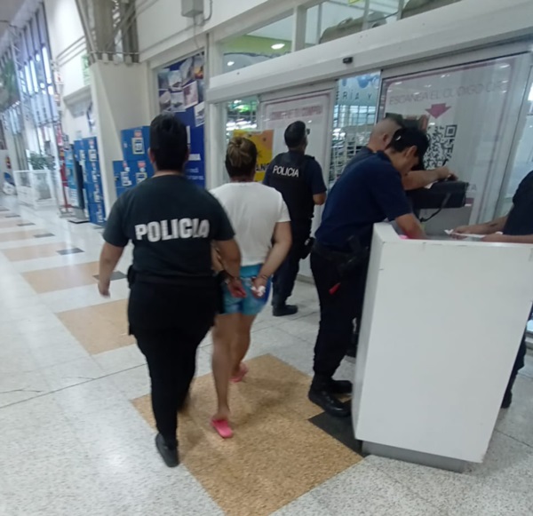 Una de las “Mecheras” es llevada por personal policial al ser atrapada.