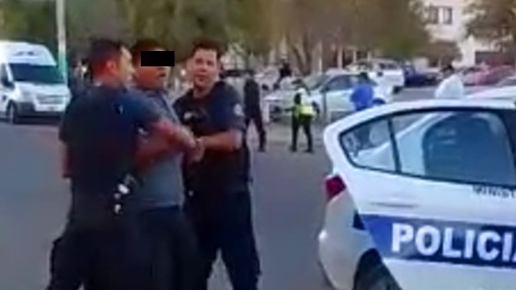 Uno de los demorados forcejeando con los efectivos policiales