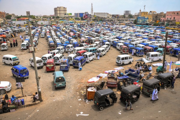 Minibuses y tuk-tuks de Port Sudan esperan pasajeros , personas desarraigadas de sus hogares tras los enfrentamientos.