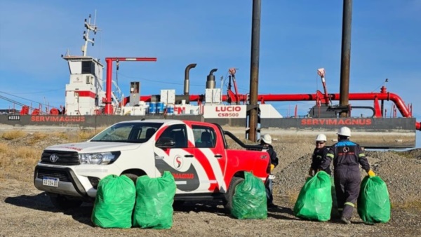 Postal. La draga detrás de la camioneta que se llevará del Puerto varias bolsas de residuos repletas. 