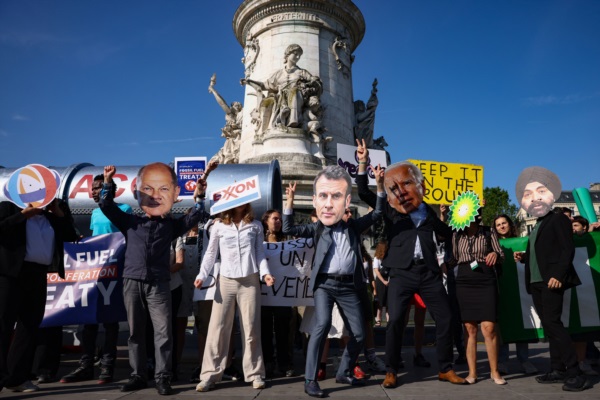 Manifestantes con máscara del canciller alemán Olaf Scholz y el presidente francés Emmanuel Macron.