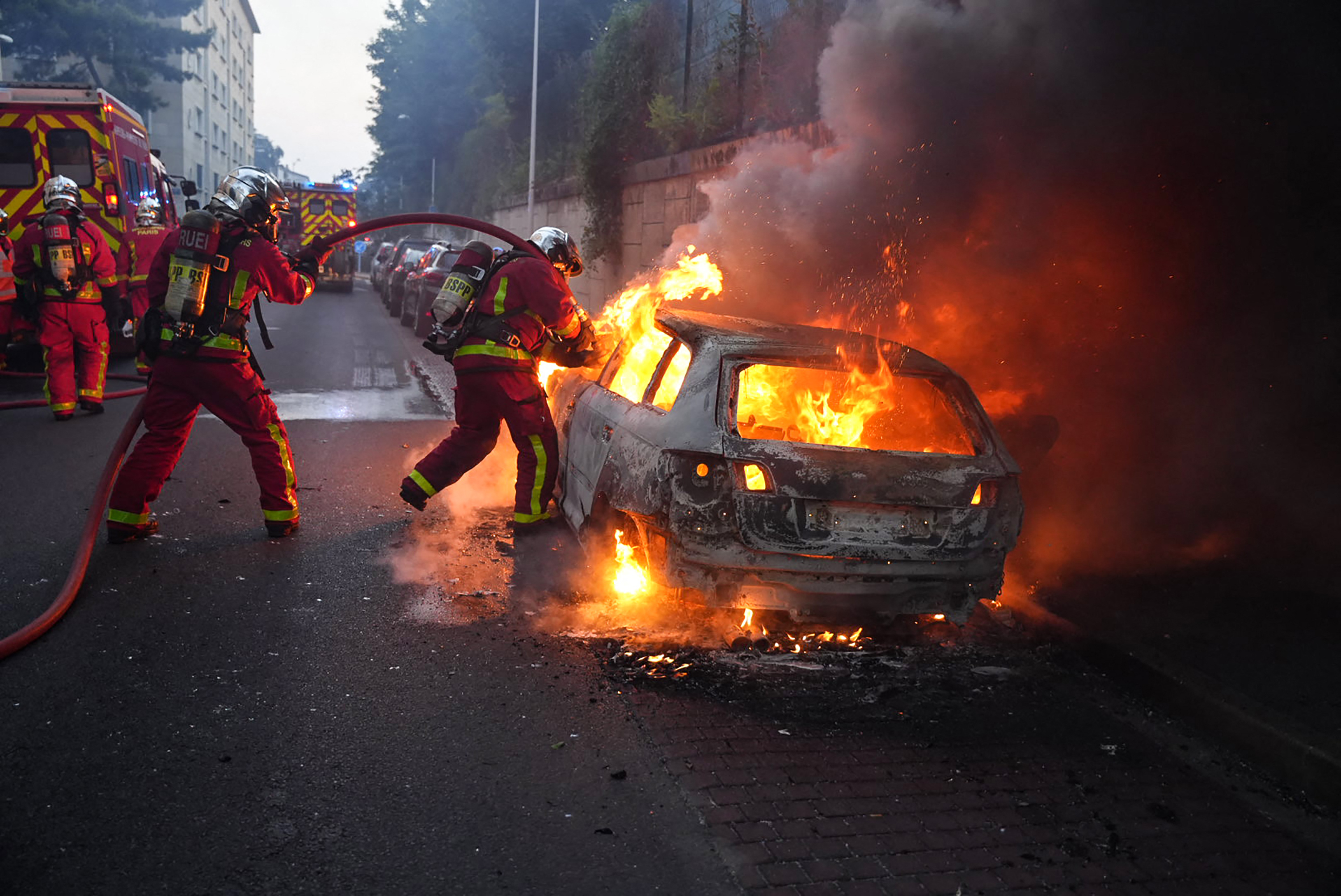 Los bomberos trabajan para apagar un automóvil en llamas al margen de una manifestación en Nanterre, al oeste de París.
