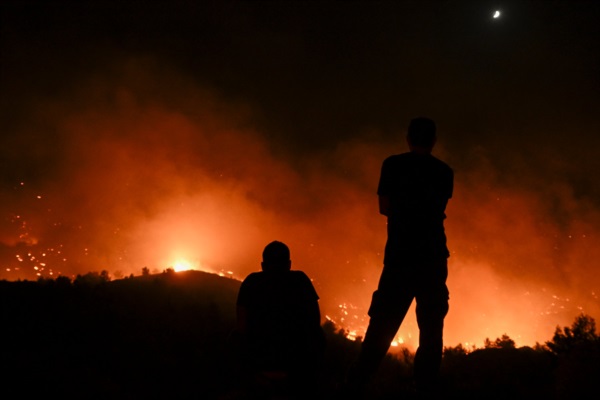 La gente observa los incendios cerca del pueblo de Malona en la isla griega de Rodas.